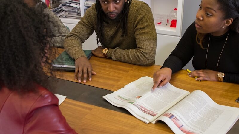 Black students studying together over a book