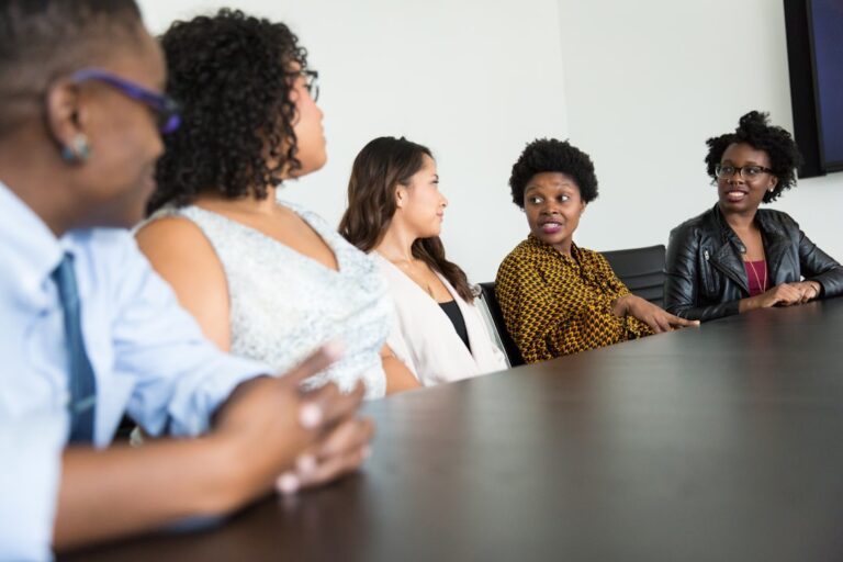 Diverse Black professionals collaborating and discussing around a table